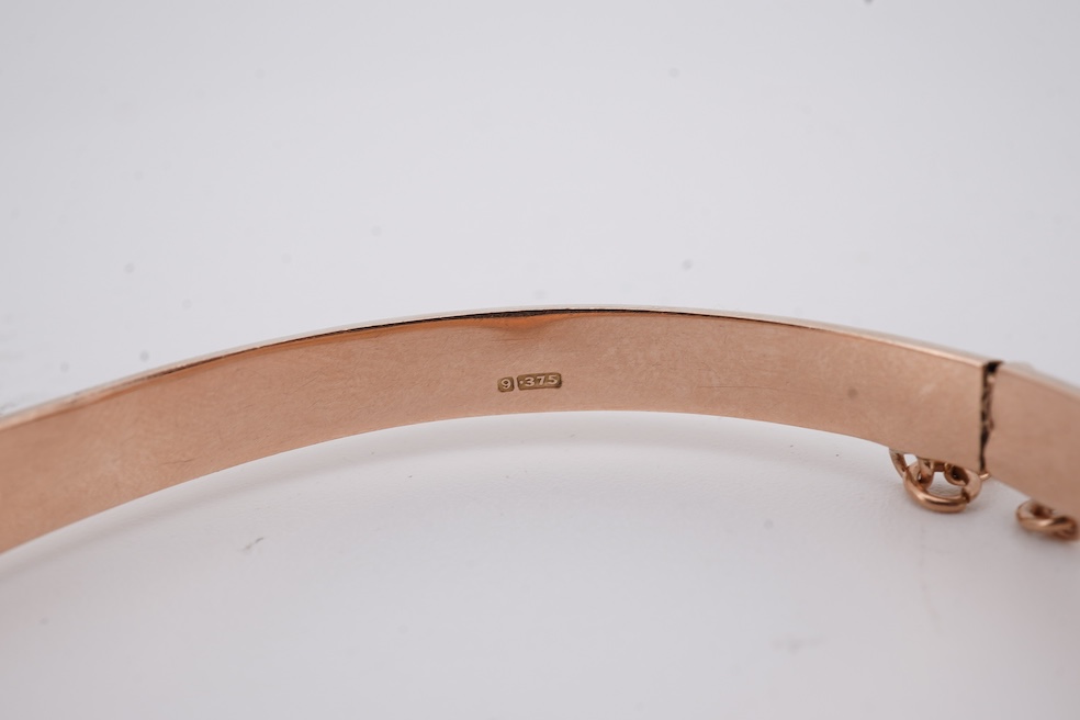 A George V part engraved 9ct gold hollow hinged bangle, Birmingham, 1911, interior diameter 57mm, 5.5 grams. Condition - poor